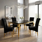 A luxury 5-piece dining set featuring a rectangular black marble-top table with gold legs and four matching black tufted velvet chairs with gold legs, shown in a modern dining room setting.