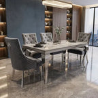A modern 5-piece dining set featuring a rectangular marble-patterned table with a polished silver chrome frame and six matching tufted gray upholstered dining chairs with silver legs, set in a contemporary dining room with gray marble floors.