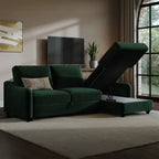 A dark green upholstered sectional sofa with a chaise lounge and raised lift-up ottoman, shown in a styled living room setting with a beige rug, wall art, and a window.