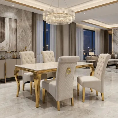 A luxury dining room set featuring a rectangular white marble-top table with ornate gold legs, surrounded by six tufted cream upholstered dining chairs with gold legs, set in a high-end modern dining room.