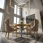A luxury dining room set featuring a round gold table and four tufted beige velvet chairs with gold legs and decorative lion head armrests, set in a modern high-ceilinged room with geometric wall panels.