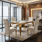 A luxury dining set featuring a rectangular table with a white marble top and ornate gold legs, surrounded by six tufted cream upholstered chairs with gold accents, set in a modern high-end dining room.