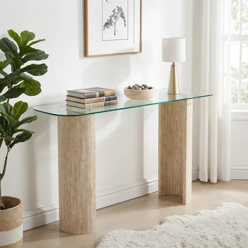 A modern console table with a clear glass top and two light wood cylindrical legs, 