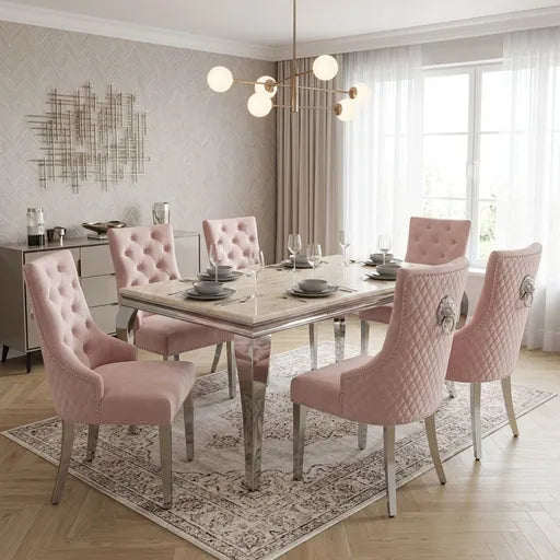 A pink upholstered dining set with a rectangular cream marble top table and six tufted and quilted chairs, styled in a bright, modern dining room.