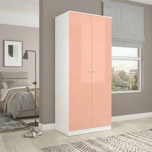 A tall two-door wardrobe with glossy peach-pink doors and a white frame, shown in a modern bedroom setting.