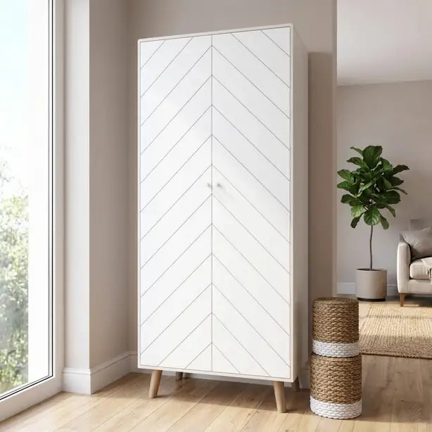 A tall white two-door wardrobe with a geometric chevron pattern on the doors and light wood legs, shown in a modern living room setting.