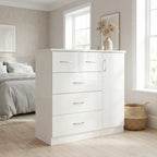 A white high-gloss three-drawer chest with a matching cabinet door and silver handles, styled in a bright, modern bedroom next to a bed and window.