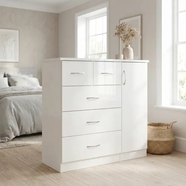 A white high-gloss three-drawer chest with a matching cabinet door and silver handles, styled in a bright, modern bedroom next to a bed and window.