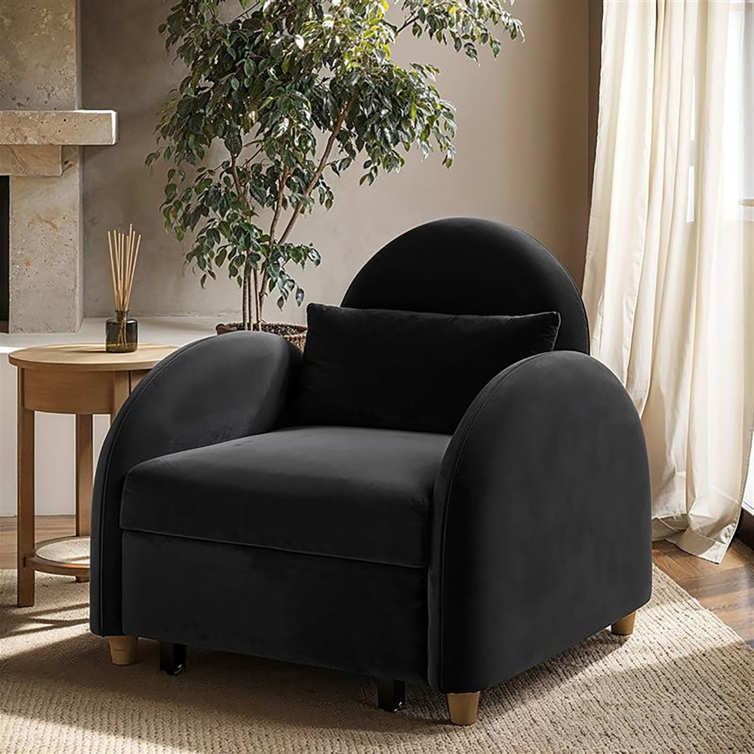 Black armchair in a living room setting with a plant and side table.