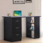 Black desk with laptop, clock, and decor items in a room setting.