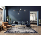 Modern living room with a dark blue sofa, brown armchair, and coffee table.