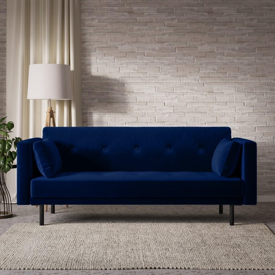 Blue sofa bed in a room with a textured wall and lamp.