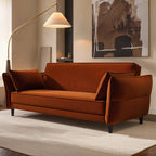 Burnt orange sofa bed in a living room with a lamp and abstract painting.