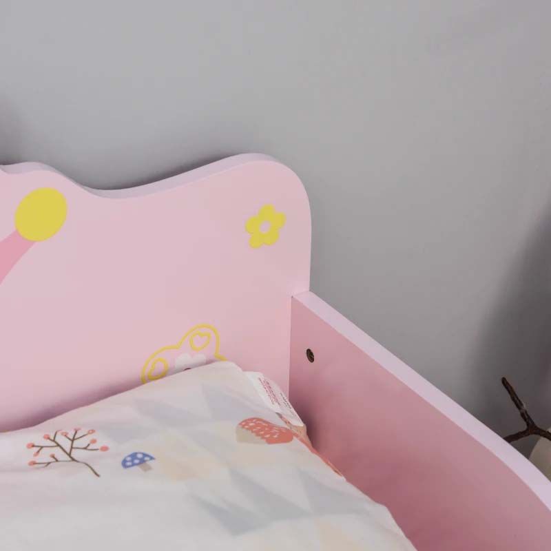 Children's bed with pink headboard and floral design against a gray wall