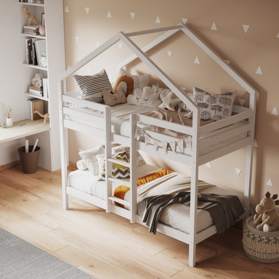 Children's room with a white house-shaped bed, pillows, and toys on a wooden floor.