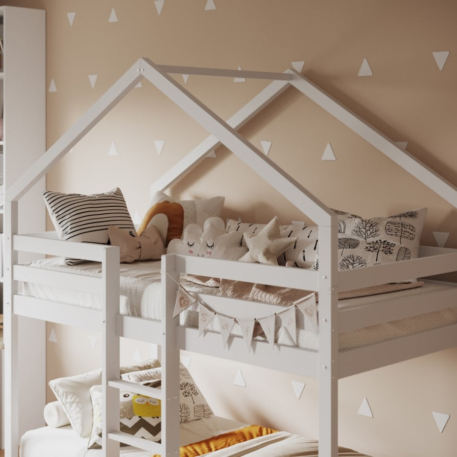 Children's room with a white house-shaped bed and decorative pillows.