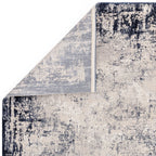 Close-up of a textured area rug with a mix of black, white, and gray colors.