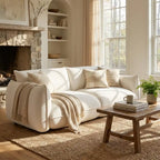 Cozy living room with a white sofa, wooden coffee table, and large windows.