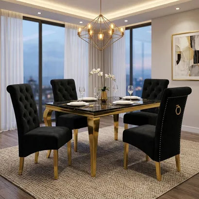 A luxury dining room set featuring a rectangular black marble-top table with gold legs, surrounded by four high-back cream tufted velvet chairs with gold legs and ring pulls, set in a modern high-rise apartment.