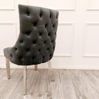 Dark gray tufted chair with chrome legs on a wooden floor.