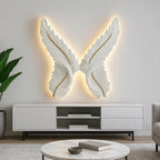 Decorative wall art with feather design illuminated by lights in a modern living room.