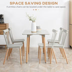 Dining table with four chairs in a room setting, emphasizing space-saving design.