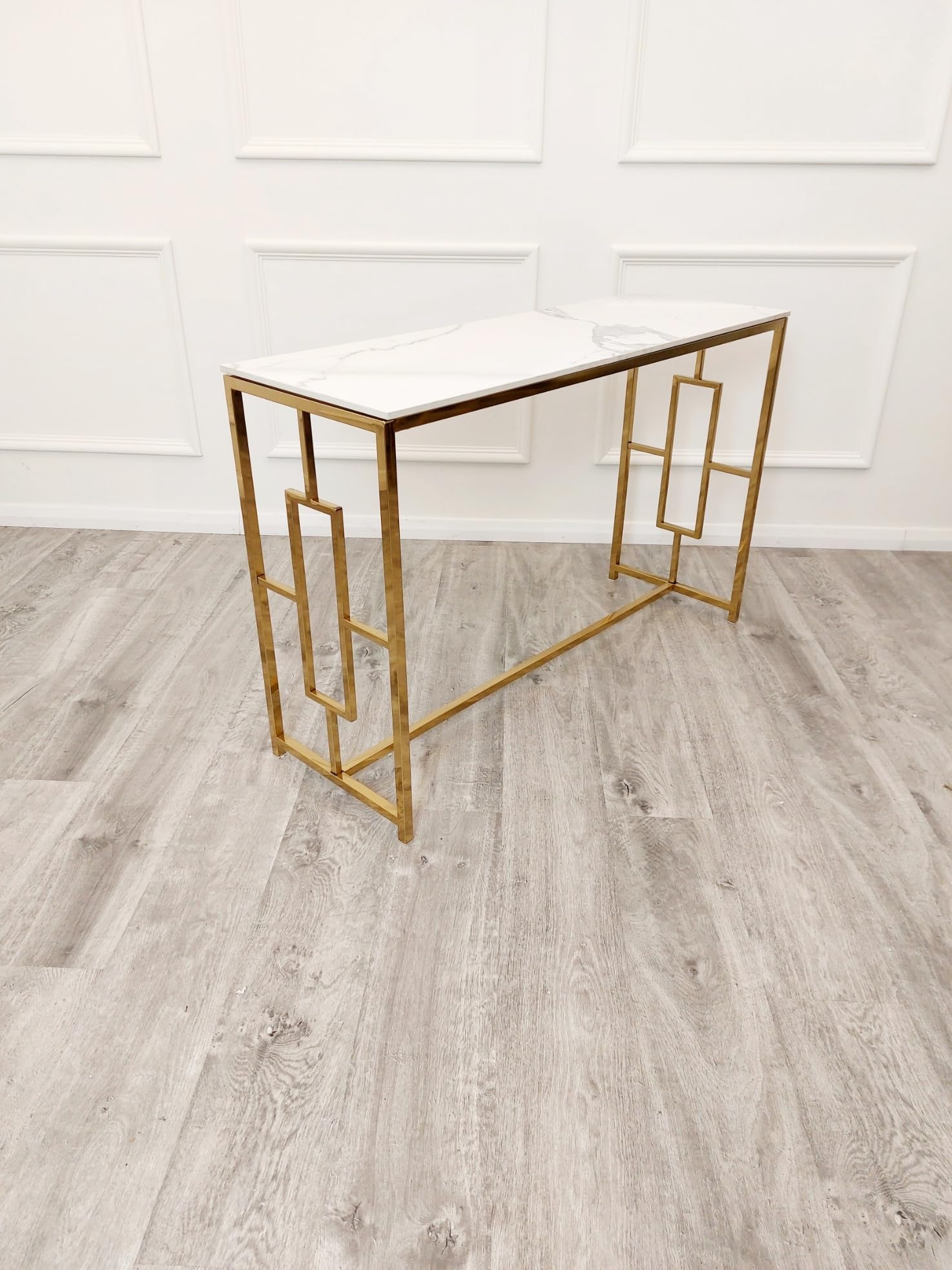Gold console table against a white wall on a wooden floor