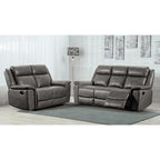 Gray reclining sofa set in a living room setting with a lamp and wall art.