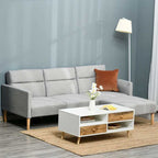 Gray sectional sofabed with a white coffee table and decorative items in a living room setting.