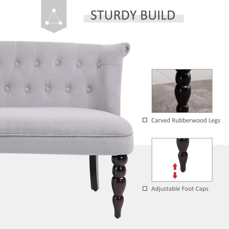 Gray tufted sofa with dark wooden legs on a white background, highlighting sturdy build features.