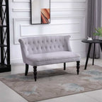 Gray tufted loveseat in a room with a rug and wall art