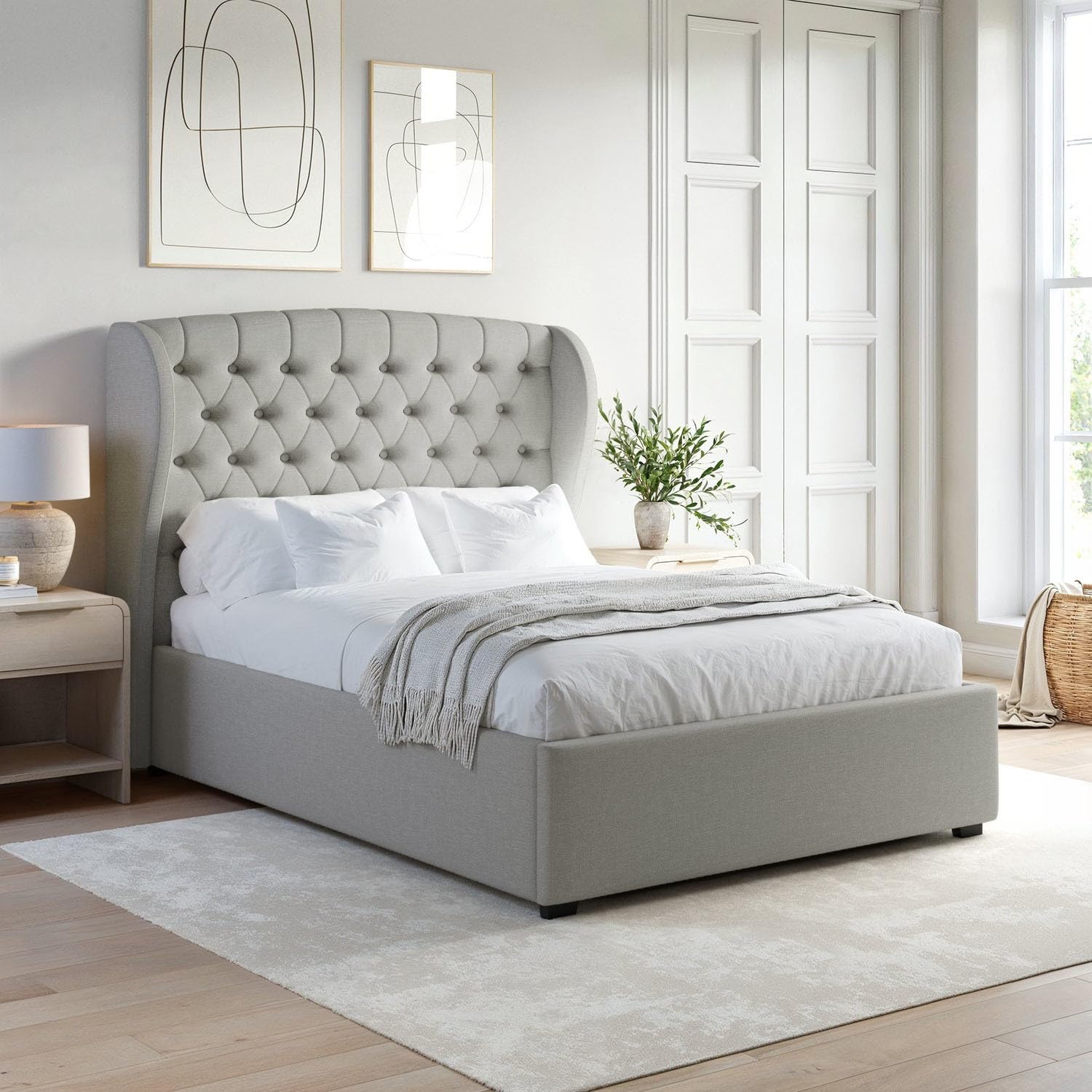 Gray upholstered bed in a modern bedroom with abstract art on the wall.
