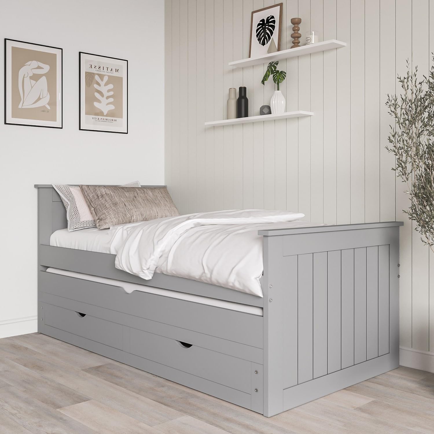 Gray wooden bed with white bedding in a room with light wood flooring and white walls.