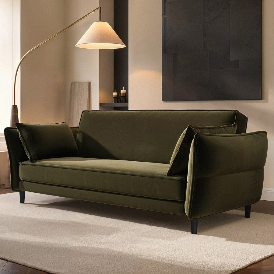Green sofa in a living room with a floor lamp and abstract painting.