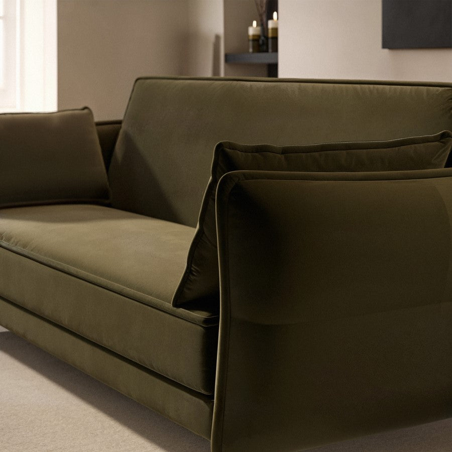 Green sofa in a room with neutral decor