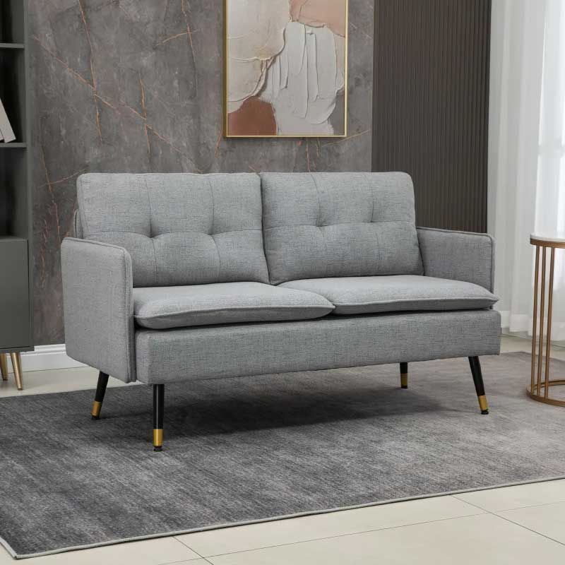 Gray sofa in a room with a marble wall and abstract art.