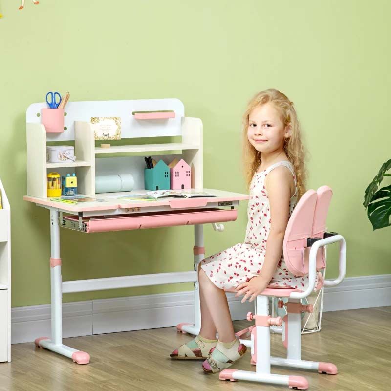 Child sitting at a pink and white desk with a green wall background