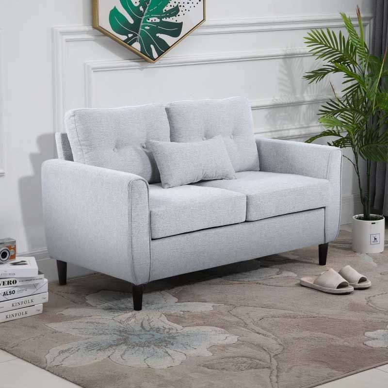 Gray sofa in a living room setting with a plant and decorative items.
