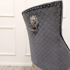 Gray quilted chair with lion head design and studs on a white background