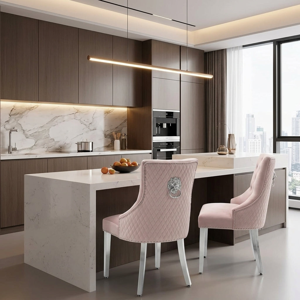 Two blush pink upholstered dining chairs with silver legs, shown in a real interior environment.