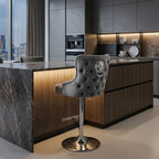 Modern kitchen with a gray tufted bar stool in front of a marble island.