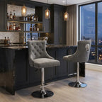 Modern kitchen with dark cabinets, marble countertops, and gray bar stools.