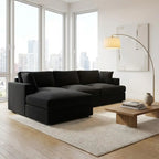 Modern living room with a black sectional sofa, wooden coffee table, and large windows.