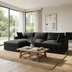 Modern living room with a dark gray sectional sofa, wooden coffee table, and large windows.