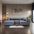 Modern living room with a gray sectional sofa and abstract painting on the wall.
