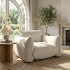 Modern living room with a white armchair, wooden side table, and large window.