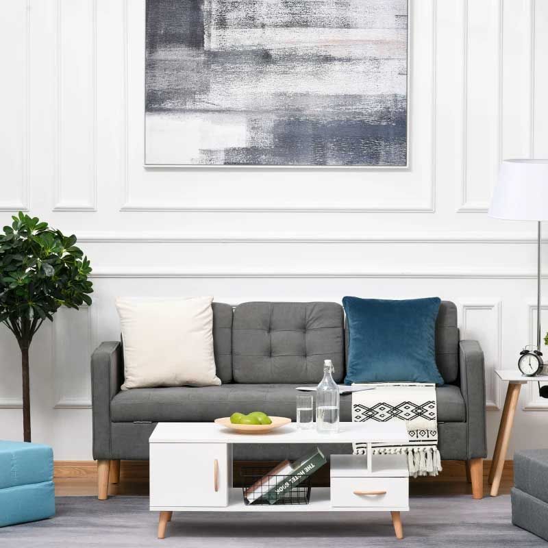Modern living room with a gray sofa, white coffee table, and abstract art on the wall.