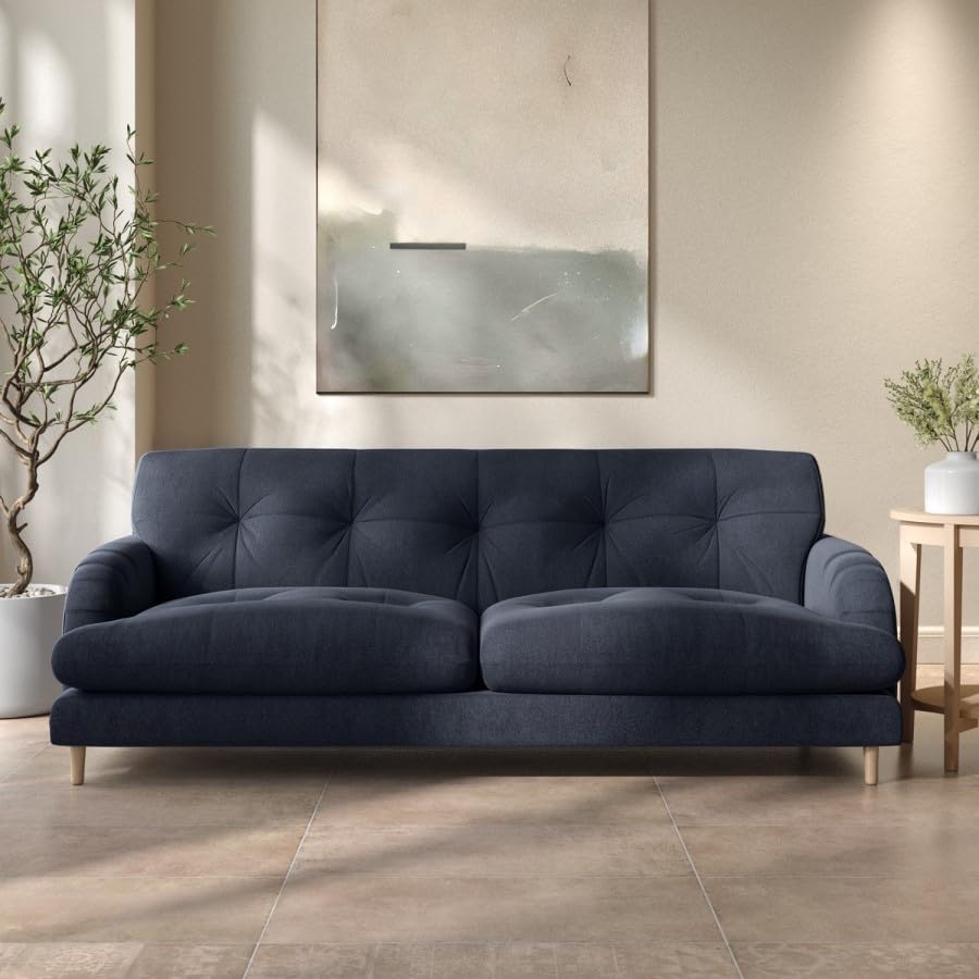 Navy blue sofa in a modern living room with a neutral color scheme.