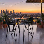Outdoor dining setup with city skyline view during sunset