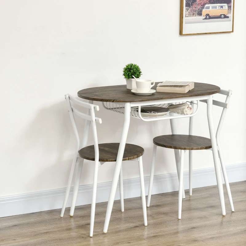 Round wooden table with two matching stools on a wooden floor against a white wall.